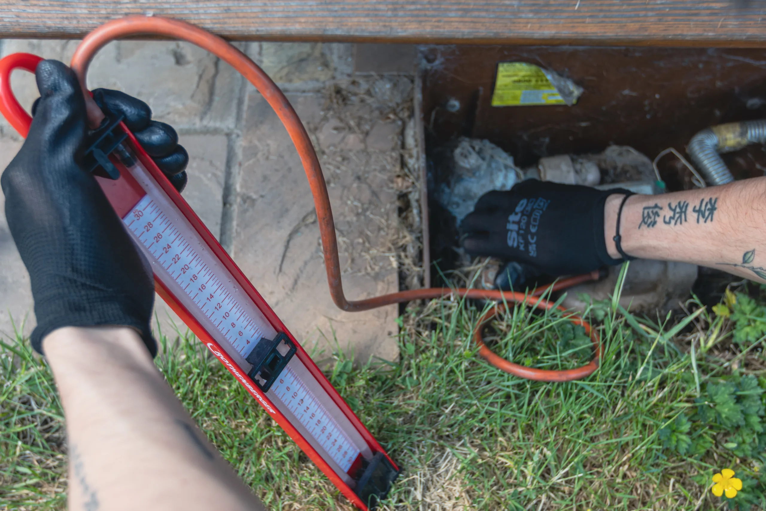 Gas Safe registered engineer testing for leaks with a gauge on the gas meter