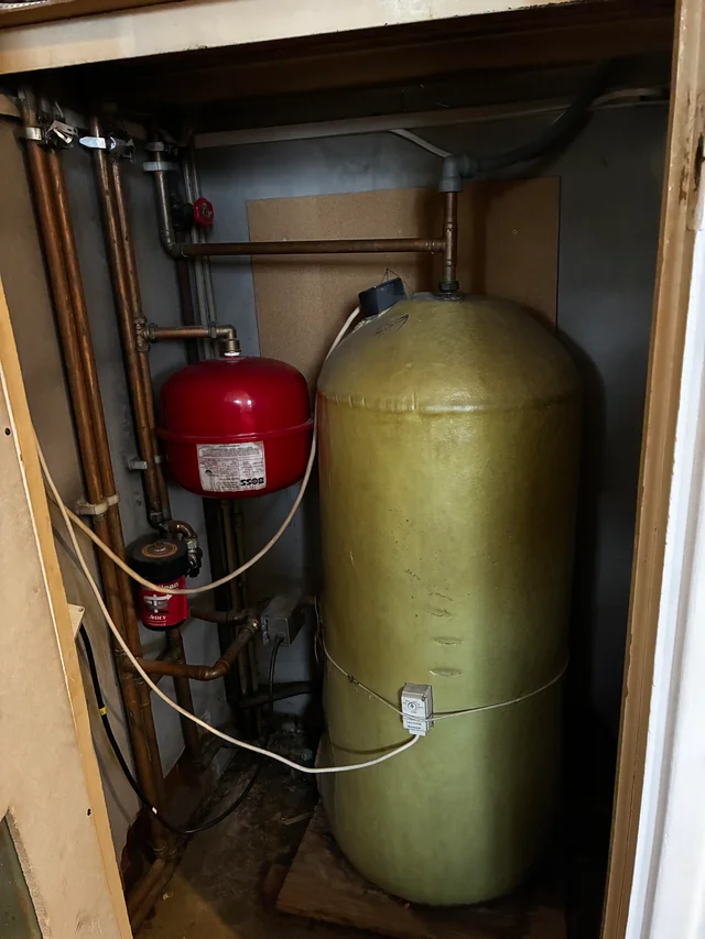 Old hot water cylinder in an airing cupboard in a house that is for sale